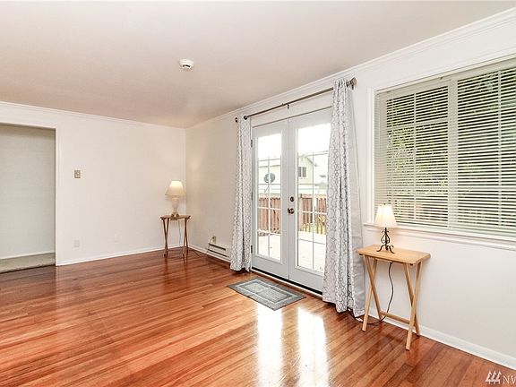 Living room with beautiful hardwoods. French door leads to a lovely deck and fenced backyard. 