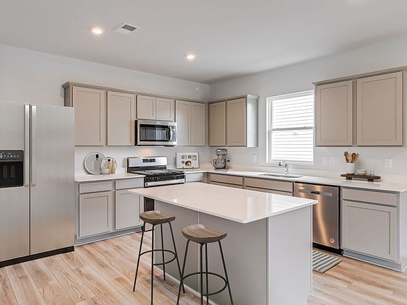 Beautiful Open Kitchen with an island and stainless steel appliances. - Model Representation
