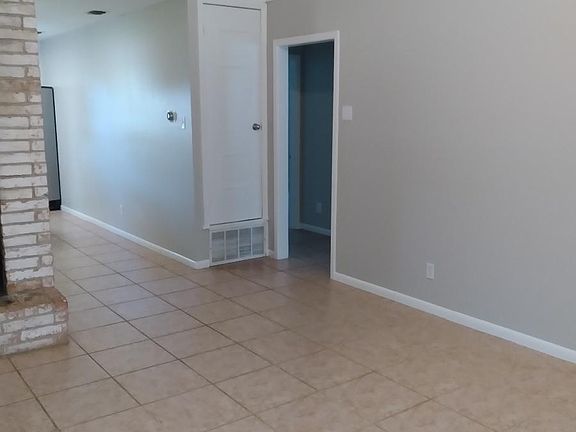 Fresh grey & white paint throughout the entire interior. Spacious living room connects to the kitchen/dining beyond the brick fireplace