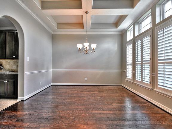 Dining room with trayed ceilings and plantation shutters
