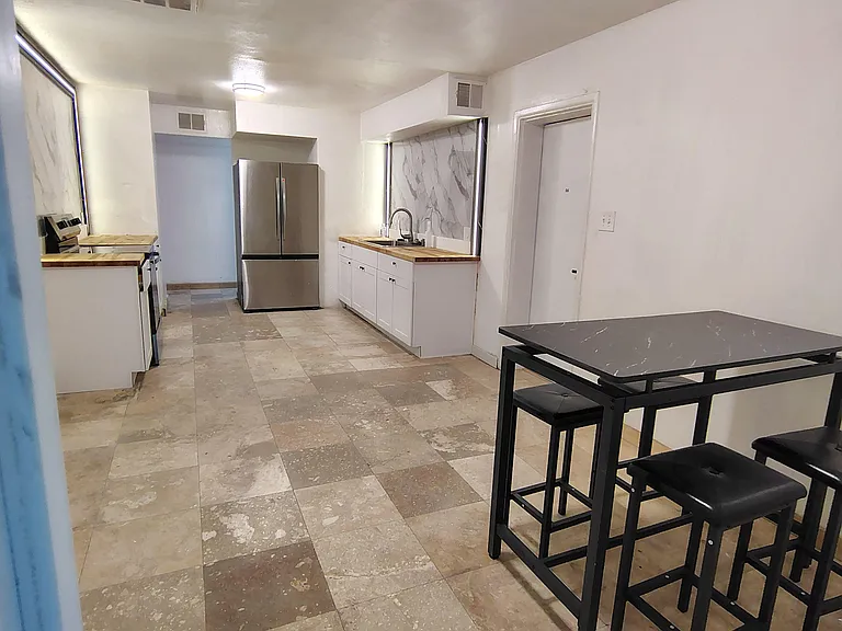 Eat-in kitchen with stainless French-door fridge, generous counter space, and a handy breakfast table for meals or work.