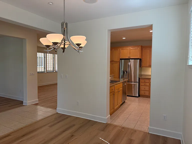 Bright, airy living room and dining room feature large windows, vinyl flooring throughout.