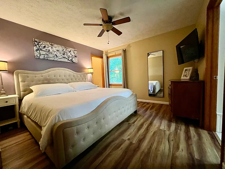 Primary bedroom with TV and en suite bathroom