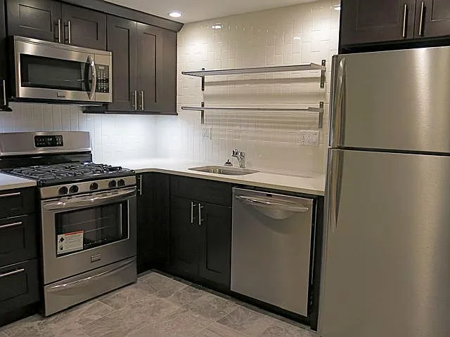 great kitchen for a cook - quartz counter tops, stainless steel appliances, gas stove and range, dishwasher, microwave, tile floor with warming