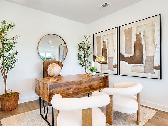 A cozy and inviting entryway with a rustic wooden console table, a large round mirror, and abstract