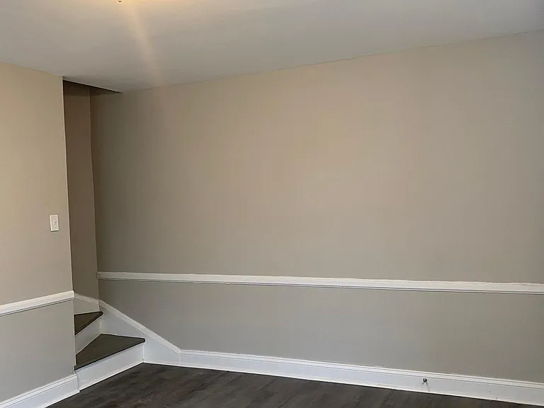 Different angle of the Den/living room and beginning of staircase that leads to the 2nd floor