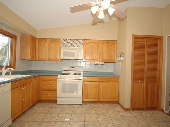 Oak Cabinetry, Tile Floor,Gas Stove , Built in Microwave & Dishwasher, Celing Fan Light