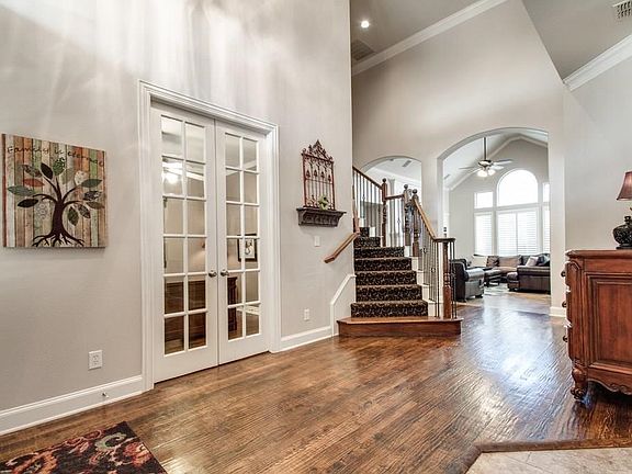 Beautiful handscraped hardwood flooring in the entry leading to the Family Room & wrought iron staircase.