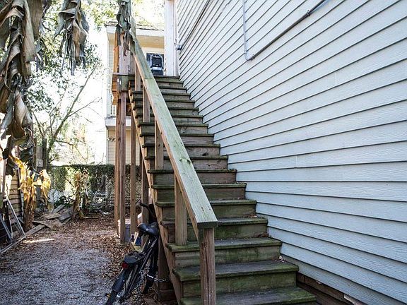Upstairs walking up to front door, with wrap around balcony. There is a gate on the street level prior to entry at this point.