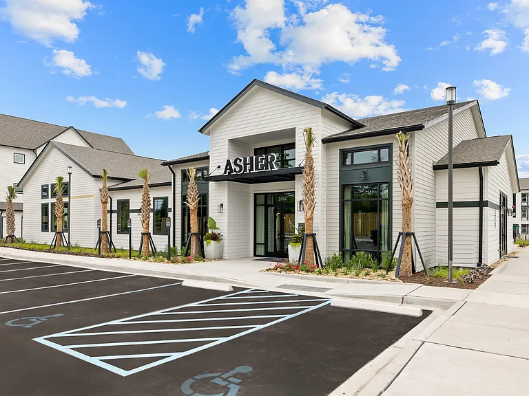 Modern apartment clubhouse entrance with contemporary architecture, landscaped walkways, and welcoming community amenities.