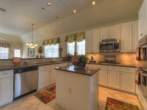 Phenomenal gourmet island kitchen boasts granite countertops, travertine backsplash, recessed lighti