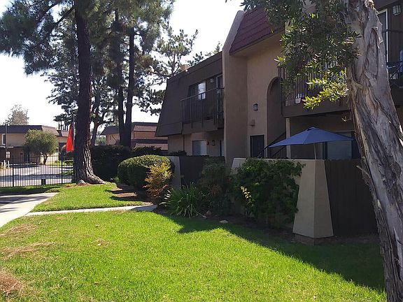 Private porches and stately pine trees at Teton Pines Apartments in Escondido, California.