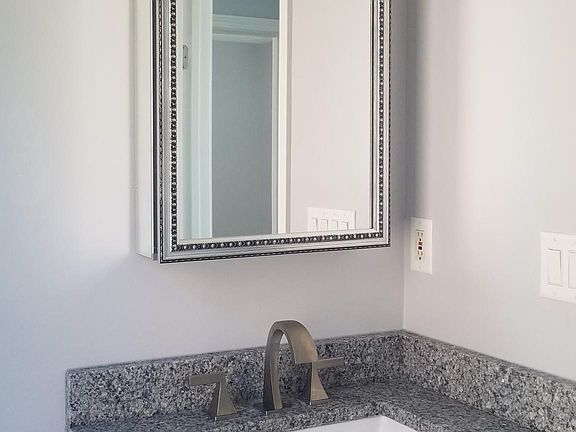 Bathroom with new cabinets and granite counters, plus medicine cabinet for extra storage with double sided mirror