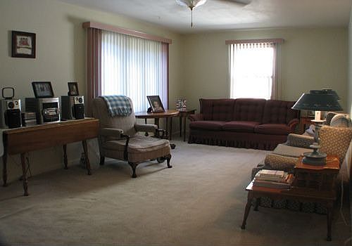 Living room w/lighted ceiling fan & bow window.