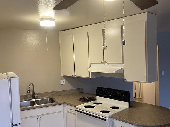 Beautiful fan in kitchen, formica countertops, double steel sink, all electric kitchen.