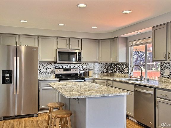 Open and Bright Kitchen with Island.  All New Kitchen Appliances Stay.