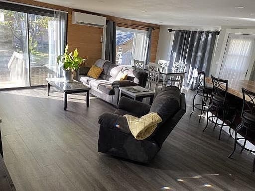 Living space with large couch, recliner, and wall mounted flat-screen tv