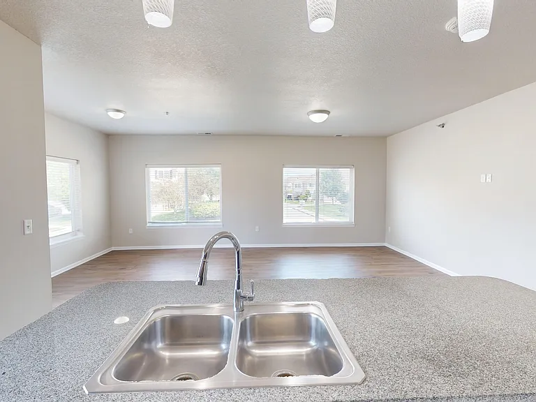 The kitchen flows into the spacious living room with large windows, providing ample natural light. The kitchen flows into the spacious living room with large windows, providing ample natural light.