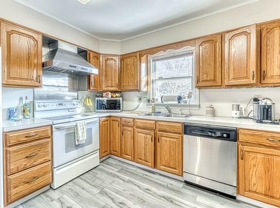 Kitchen with oak cabinets and new vinyl flooring and stainless steel dishwasher.