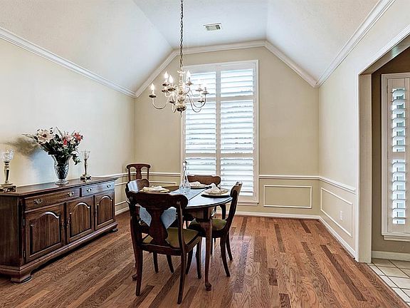 Fresh neutral paint in this elegant formal dining room with moulding, hardwoods and a view of the front yard through the plantation shutters. Pride of ownership shines through!