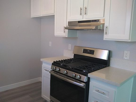 range side of kitchen, new stainless range and hood, new QUARTZ counters