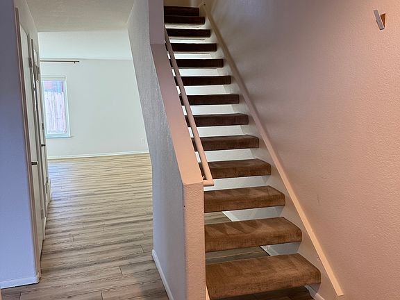Entryway to living room - space for storage under stairs
