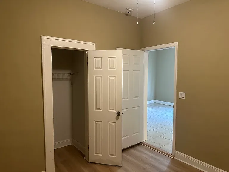 Second bedroom with new plank flooring and ceiling fan.