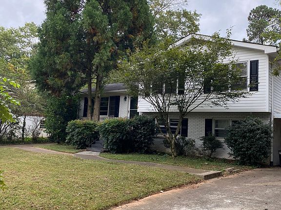 Right side with driveway to single car carport
