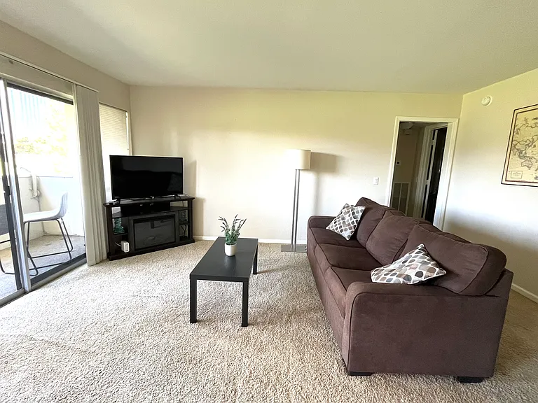 Living room with a view of the Strip and golf course. Incudes sleeper sofa, tv with a stand, WiFi router, coffee table, lamp, picture on the wall, decorative pillows