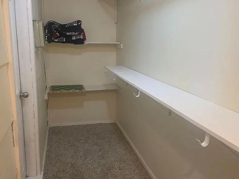 Walk-in closet with built-in shelving and a hanging rod for streamlined clothing and accessory storage.