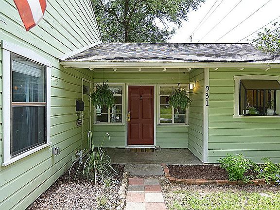 The front porch with a red door and hanging plants welcoming you to your new home
