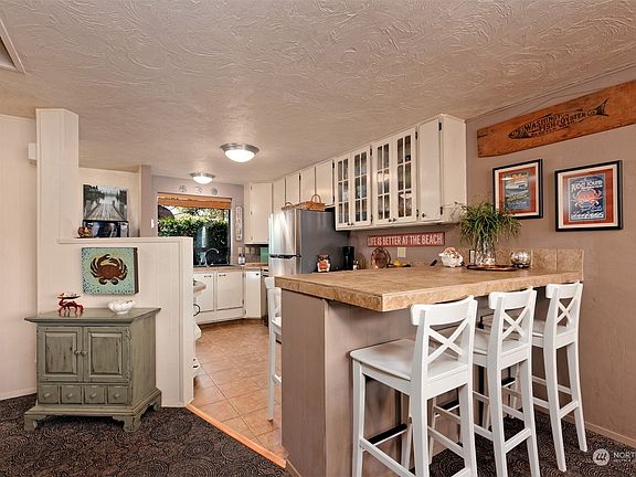 Nice updated kitchen with tile counters and a newer refrigerator and dishwasher. >