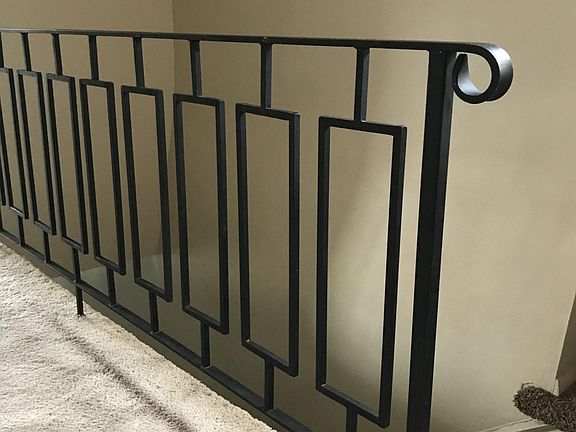 Top of the stairs with a cool geometric designed railing