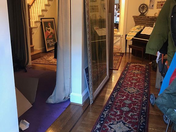 Entry hall coming into the house. The room on the left if the front den. You can see the stairs going up. To the left of the fireplace is a view through the kitchen and out the back yard.