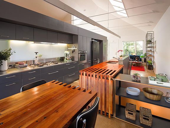 Located at the center of the home, and overlooking an open staircase to the first floor below, the Kitchen features a Miele gas cooktop, Best range hood, Miele dishwasher, Bosch oven, French-door custom-panel refrigerator with bottom freezer, Grohe faucet
