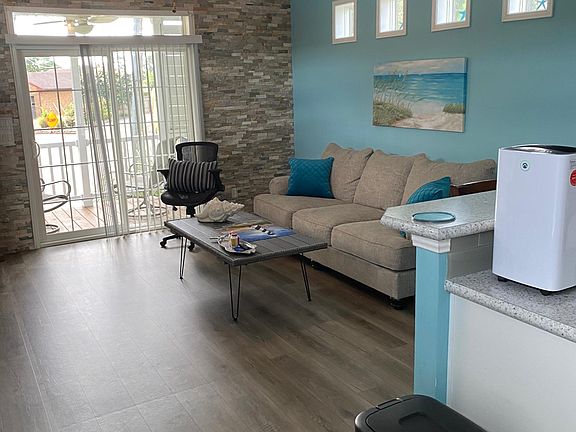 Furnished living area includes couch, tv, lazy boy, coffee table, and large tv cabinent