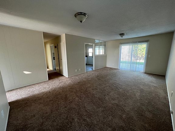 Living room. Front door on the left, sliding glass door to backyard. Hall to bedrooms, kitchen access from living room and hall.