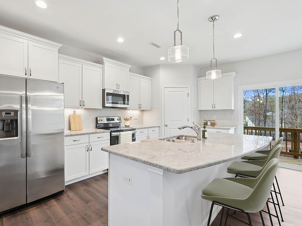 Upgrade Package Kitchen with white cabinetry, designer tile backsplash and undercabinet lighting, and granite countertops