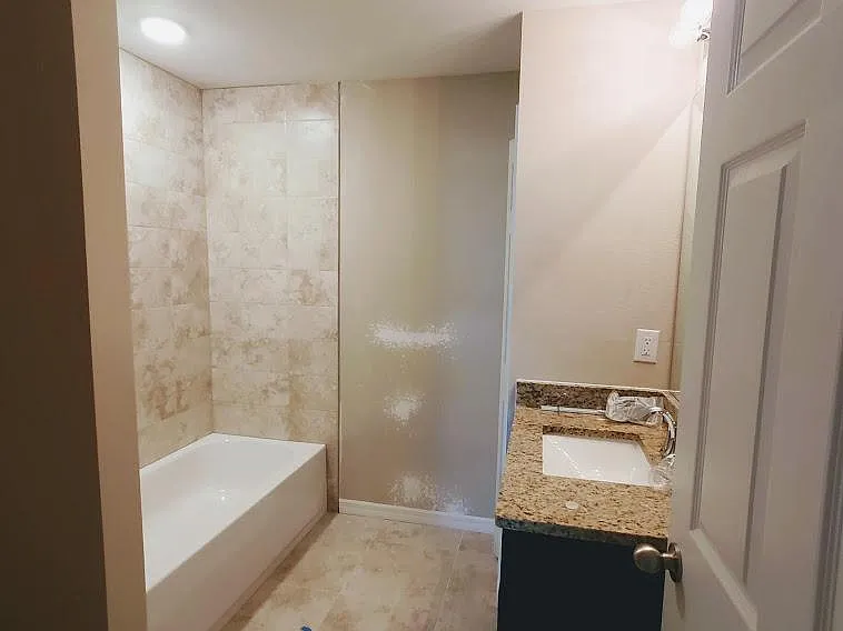 main bath with tiled tub/shower and single granite vanity