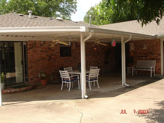 Large covered patio with two ceiling fans and gas grill connection