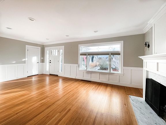 Main floor. Living room with large windows and custom blinds.