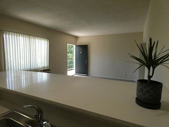 From kitchen looking across living room towards front door.