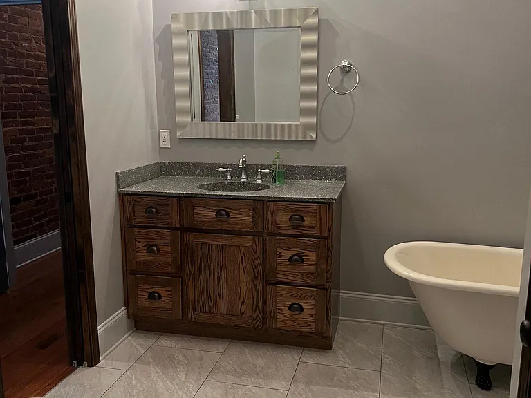 Bathroom with custom cabinets and antique claw foot bathtub.