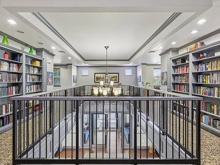 Residents enjoy the cozy library at McDermott 55 in Plano, perfect for reading or working.