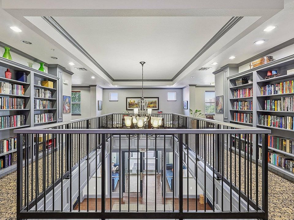 Residents enjoy the cozy library at McDermott 55 in Plano, perfect for reading or working.