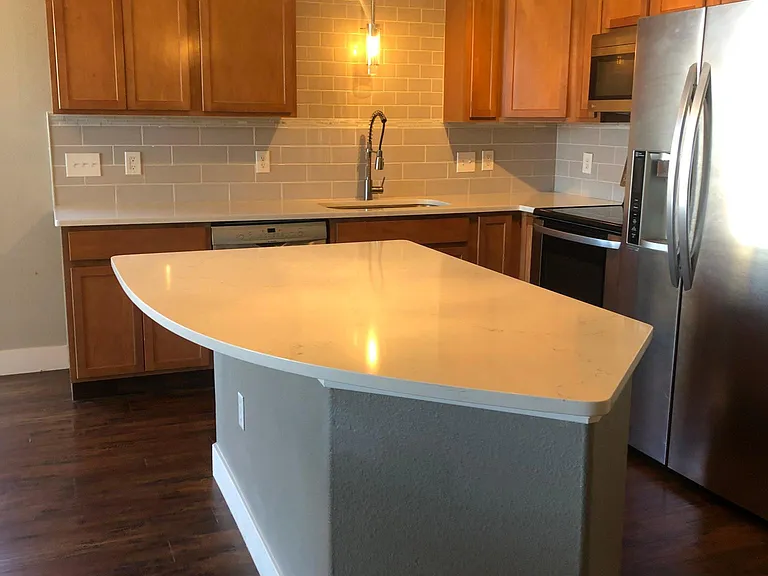 The large kitchen island with swooping countertop provides ample space for stool seating and food prep