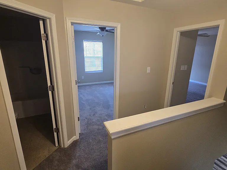 Top of stairs showing hallway full bath (left), Bedroom 2 (center), and Master (right)
