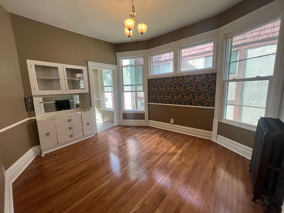 Large dining room with Built-in mirrored bar for storage and entertaining, plus 10 foot ceilings and new oak hardwood floors; tons of natural light