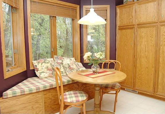 Charming bayed informal dining area with lots of storage & views of woods