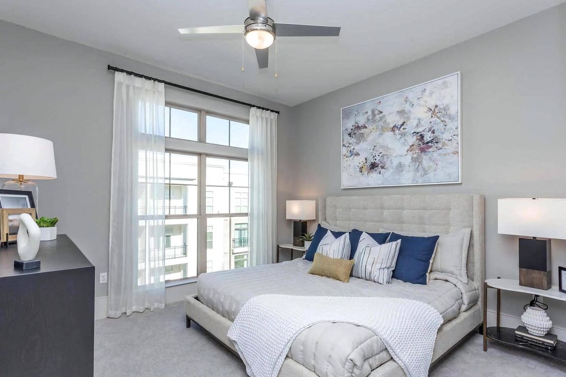 Apartment Bedroom with Upholstered Bed, Large Window and Ceiling Fan